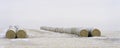 Stack of bales of hay on farm field in winter Royalty Free Stock Photo