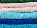 Stack of bath towels on light wooden background closeup.Pile of rainbow colored towels.Top view. Royalty Free Stock Photo