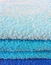 Stack of bath towels on light wooden background closeup.Pile of rainbow colored towels.Top view. Royalty Free Stock Photo