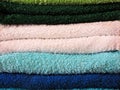 Stack of bath towels on light wooden background closeup.Pile of rainbow colored towels.Top view. Royalty Free Stock Photo