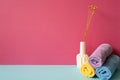 Stack of bathroom shower towels with vase of dry flower on skyblue shelf. pink wall background Royalty Free Stock Photo