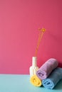 Stack of bathroom shower towels with vase of dry flower on skyblue shelf. pink wall background Royalty Free Stock Photo