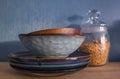 stack of ceramic blue and turquoise plates and dishes on a wooden shelf. Against the background of dark wallpaper Royalty Free Stock Photo