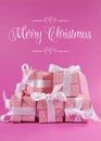 Stack of beautiful pink polka dot gift presents with Merry Christmas greeting