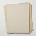 A stack of beige cardboard sheets is arranged neatly on a flat surface. The top sheet Royalty Free Stock Photo