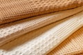 Stack of beige and cream colored waffle kitchen towels folded into folds close-up