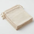 Stack of beige drawstring bags, neatly folded, resting on a white surface. Made from Royalty Free Stock Photo