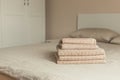 Stack of beige hotel towel on bed in bedroom interior. Vintage toning Royalty Free Stock Photo