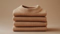 Stack of Beige Knit Sweaters on Neutral Background Royalty Free Stock Photo