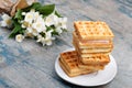A stack of Belgian waffles on a white plate, on a wooden painted background. Royalty Free Stock Photo