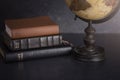 Stack of Bibles and a Globe on a Dark Background Royalty Free Stock Photo