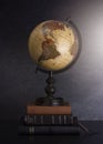 Stack of Bibles and a Globe on a Dark Background