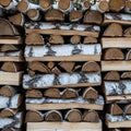Stack of birch firewood cut into uniform logs, neatly arranged in horizontal rows. The Royalty Free Stock Photo