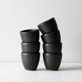 Stack of black ceramic bowls arranged in two leaning columns with a minimalist Royalty Free Stock Photo