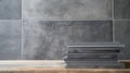 A stack of black notebooks on a wooden surface against a gray tiled background. The scene is minimalistic and modern Royalty Free Stock Photo