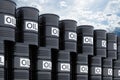 Stack of black oil barrels against blue sky, 3d rendering Royalty Free Stock Photo