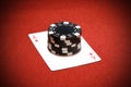 Stack of black poker chips on a red ace card Royalty Free Stock Photo