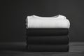 Stack of black and white folded clothes on dark background. mockup Royalty Free Stock Photo