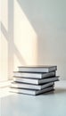 Stack of blank books on white surface. Simple mockup design. Books dark covers, white pages. Natural light casts shadows. Royalty Free Stock Photo