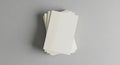 A stack of blank off white rectangular paper strips arranged vertically on a neutral gray surface Royalty Free Stock Photo