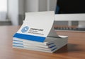 Stack of blank white notepads with blue branding isolated on white background Royalty Free Stock Photo