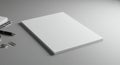 A stack of blank white paper is placed on a smooth, gray surface. Nearby, a pen with a Royalty Free Stock Photo