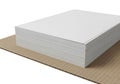 A stack of blank white paper rests on a corrugated cardboard surface ready for creative projects Royalty Free Stock Photo