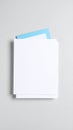 Stack of blank white paper sheets with a blue card on a gray background Royalty Free Stock Photo