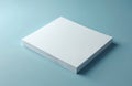 Stack of blank white paper sheets rests on a plain light blue surface. This image is perfect for design mockups, backgrounds, or Royalty Free Stock Photo