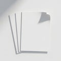 A stack of blank white paper sheets with a shadow cast on a plain background Royalty Free Stock Photo