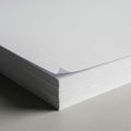 Stack of blank white paper sheets with sharp, smooth edges on a grey surface Royalty Free Stock Photo