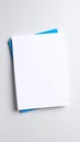 Stack of blank white paper sheets on top of blue paper on a gray surface Royalty Free Stock Photo