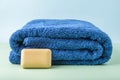 Stack of blue clean bath towels and handmade eco soap, beauty and massage spa concept Royalty Free Stock Photo
