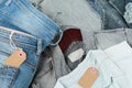 Stack of blue jeans, shirts and empty tags from craft paper