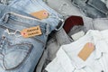 Stack of blue jeans, shirts and tag with inscription second hand Royalty Free Stock Photo
