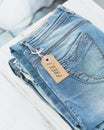 Stack of blue jeans and tag with inscription free on white background