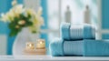 Stack of blue towels on top of a counter in a bathroom with blue walls and white towels next to a vase filled with Royalty Free Stock Photo