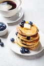 Stack of blueberry pancakes with maple syrup and butter on white breakfast plate Royalty Free Stock Photo