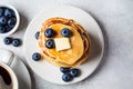 Stack of blueberry pancakes with maple syrup and butter on white breakfast plate Royalty Free Stock Photo