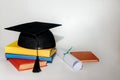 Stack of book and graduation cap on white Royalty Free Stock Photo