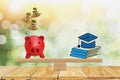 Stack book icon and red piggy bank put on scales,with blurred bokeh nature background with sunlight,concept money saving, Royalty Free Stock Photo