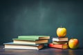 Stack of books and apple on blackboard background. Back to school concept, Glasses teacher books and a stand with pencils on the