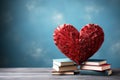 A stack of books and a big red heart on a blue background. Copy space Royalty Free Stock Photo