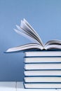 A stack of books on blue background. One hidden book on top of the pile Royalty Free Stock Photo