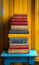 Stack of Books on Blue Table. A stack of old books sits on a blue wooden table in front of a yellow wall. Royalty Free Stock Photo