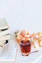 a stack of books, a book and tea in a glass Cup on bright background with branch of Orchid, the concept of love of reading, time t Royalty Free Stock Photo