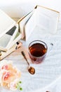 a stack of books, a book and tea in a glass Cup on bright background with branch of Orchid, the concept of love of reading, time t Royalty Free Stock Photo