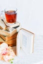 a stack of books, a book and tea in a glass Cup on bright background with branch of Orchid, the concept of love of reading, time t Royalty Free Stock Photo