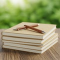 Stack of books with brown covers and white pages on a wooden table. Two brown pen Royalty Free Stock Photo