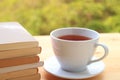 Stack of books and a cup of hot tea on a table by the window Royalty Free Stock Photo
